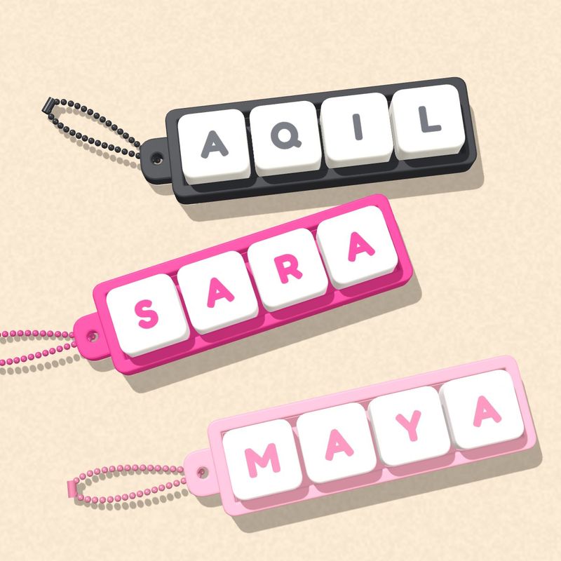 Tiga keychain: AQIL hitam, SARA magenta, MAYA pink